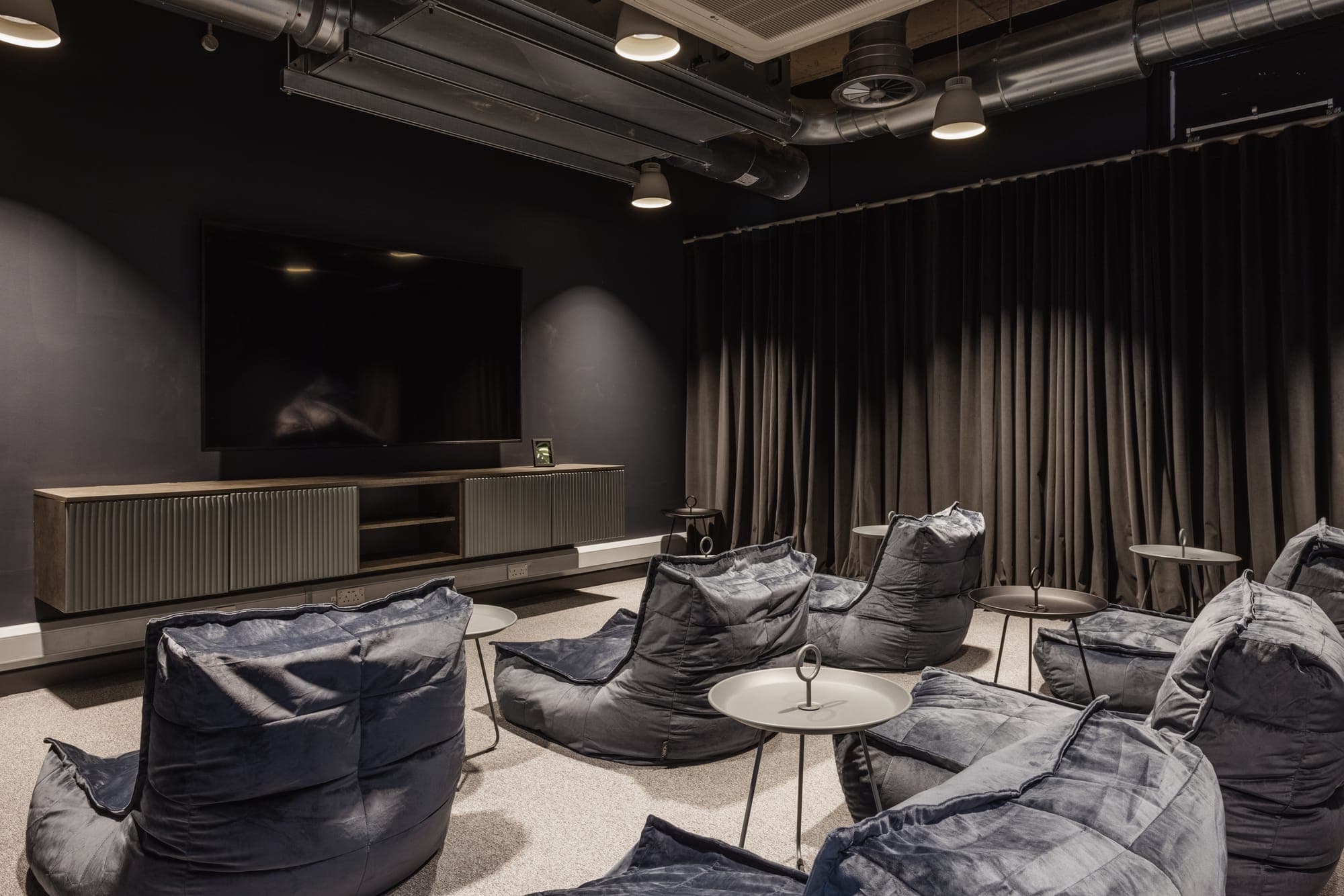 The cinema lounge screen at Globe Works, with blackout curtains and side tables