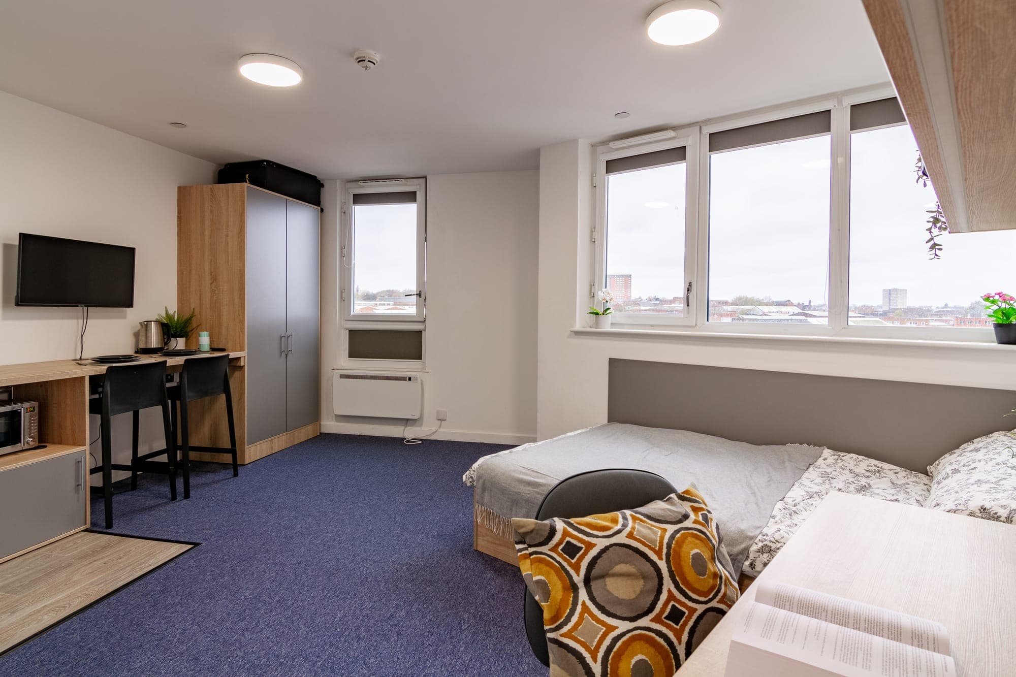 A deluxe studio at Globe Works with corner windows looking across the Birmingham skyline