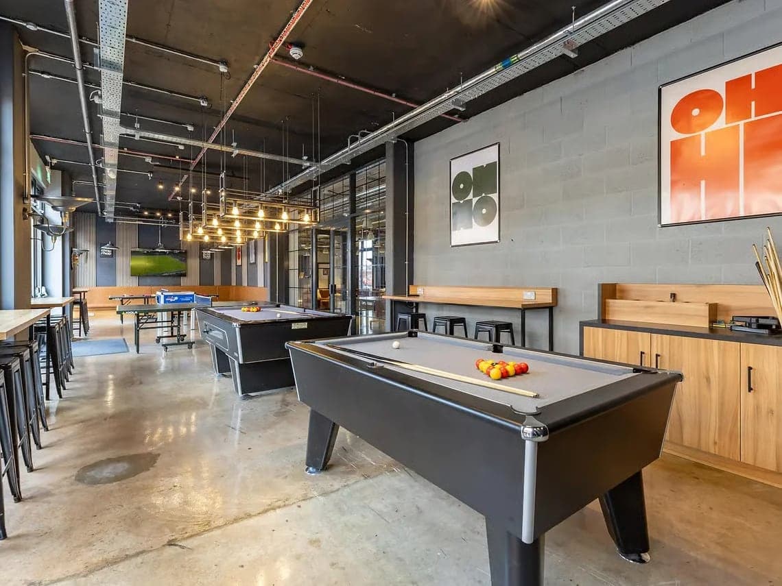 The games room at Globe Works with two pool tables and a table tennis table beyond