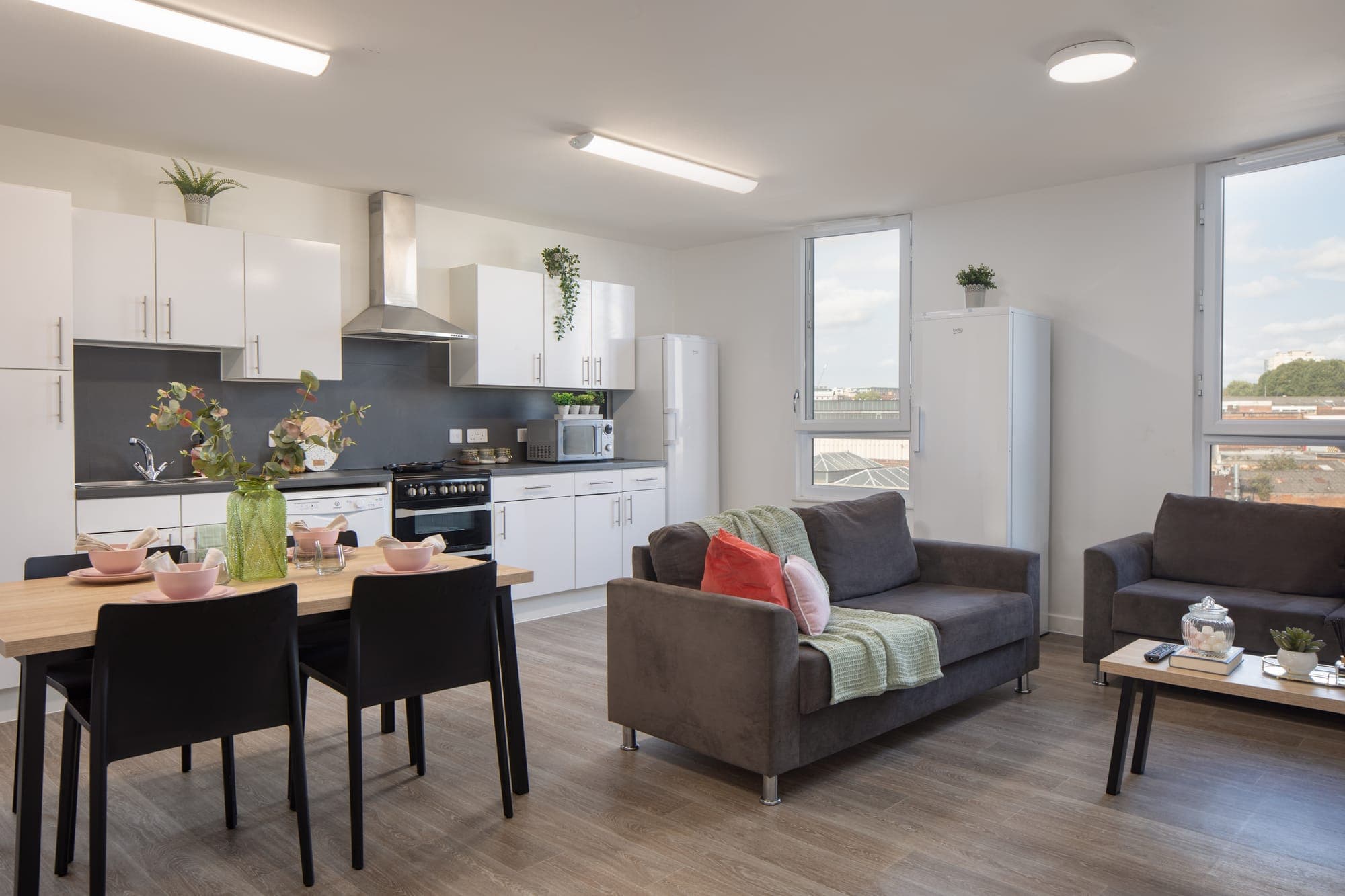 A shared kitchen and living area at Globe Works with a dining table and two sofas