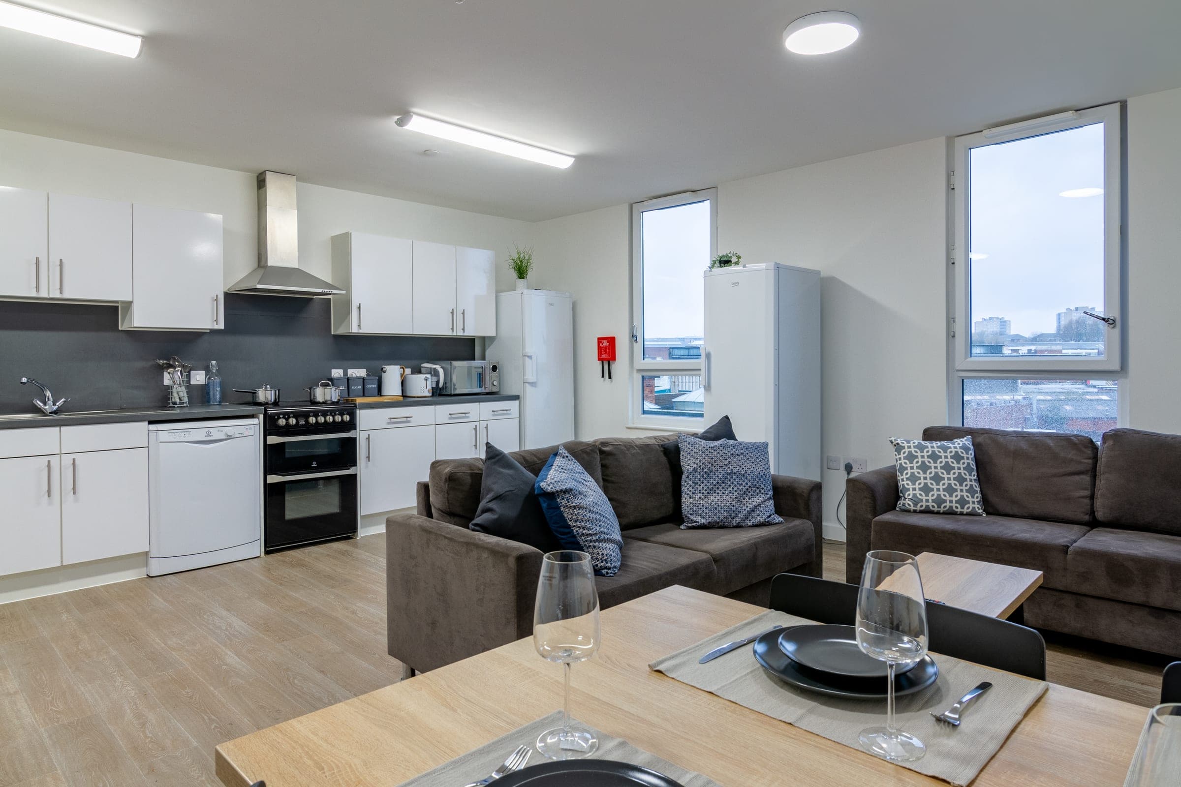 Shared kitchen and living space at Globe Works with an oven, sofas and a dining table
