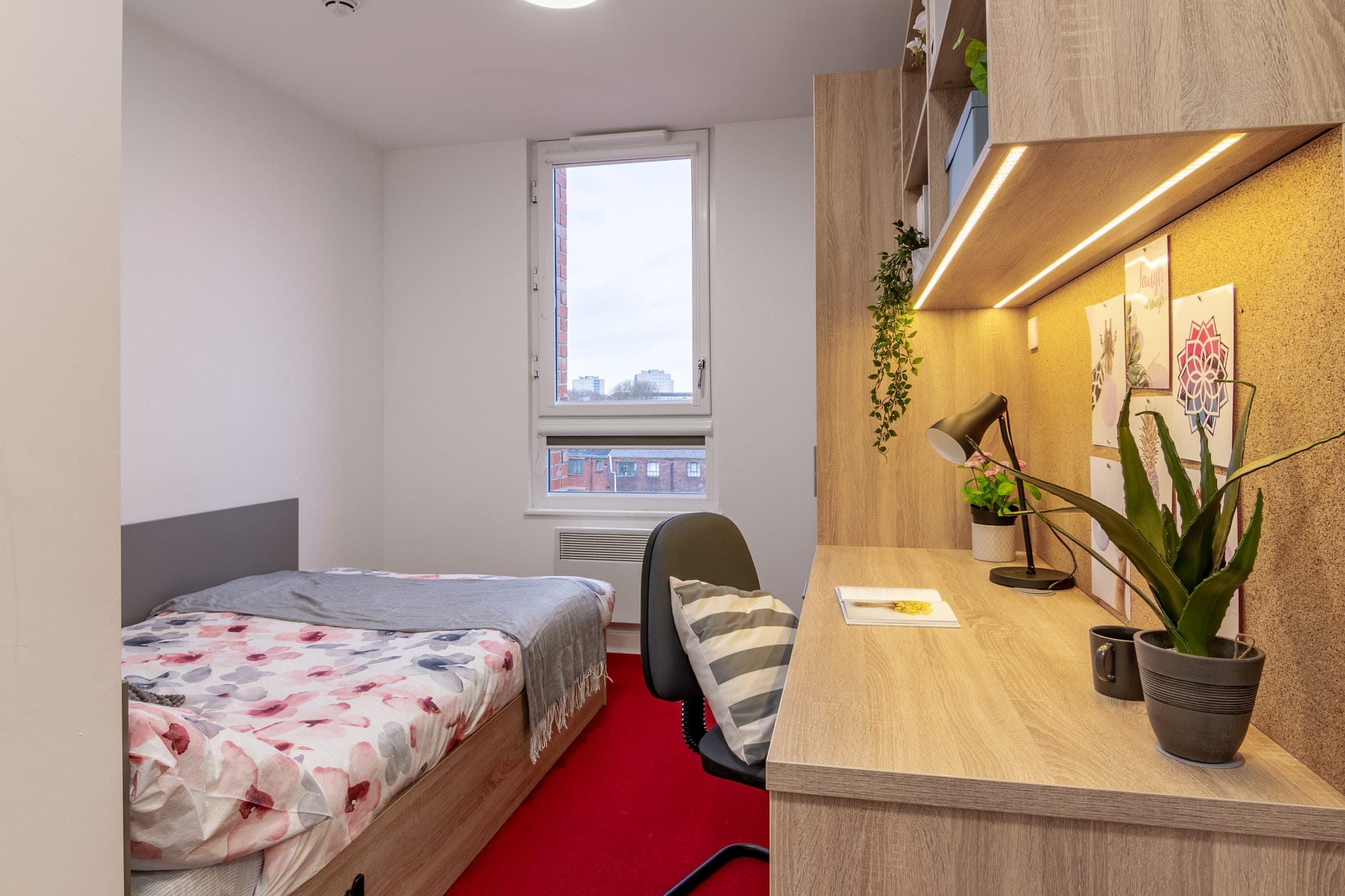 A standard en suite room at Globe Works, made up, with a study desk beside the window
